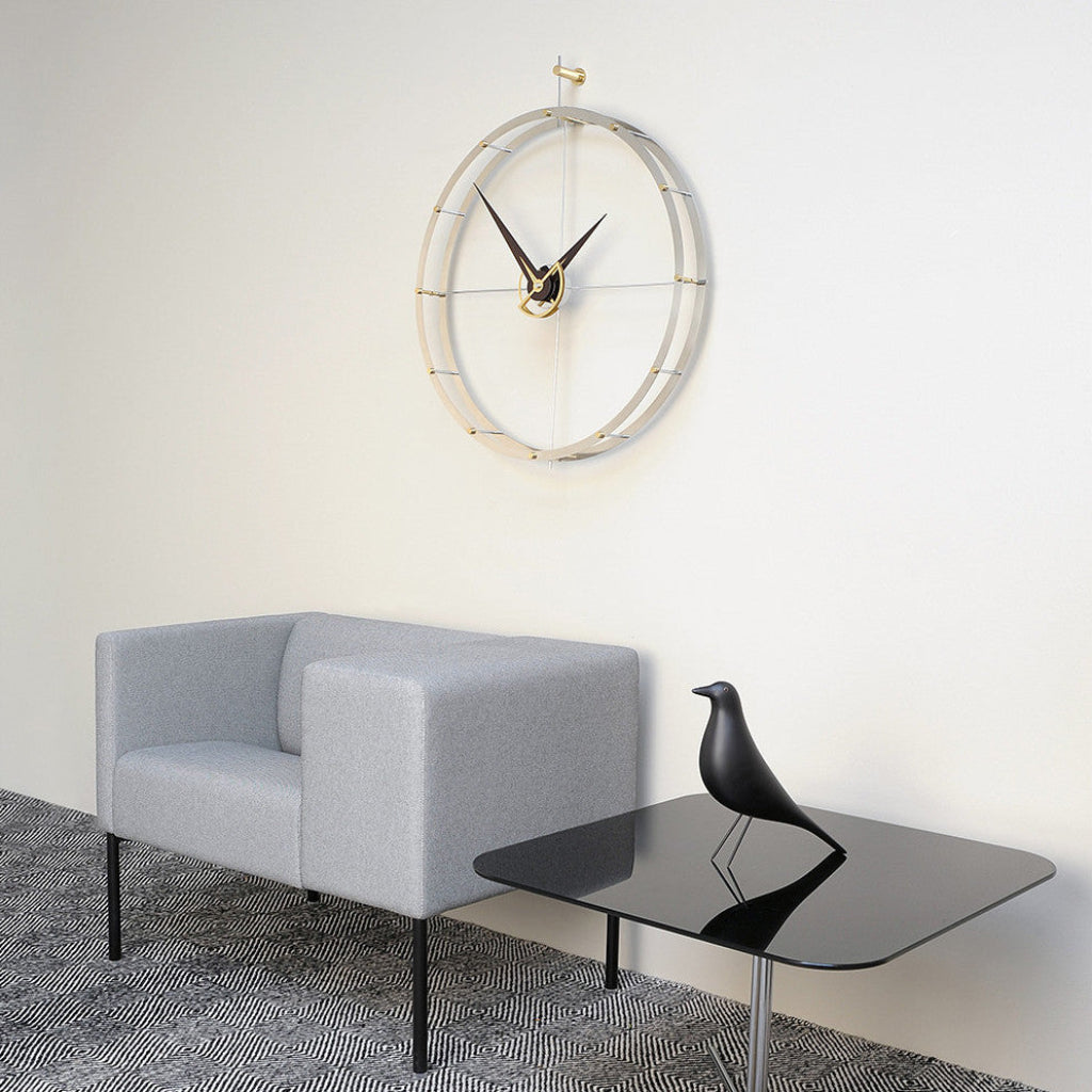 Modern living room with a gray sofa, black glass table, and decorative wall clock.