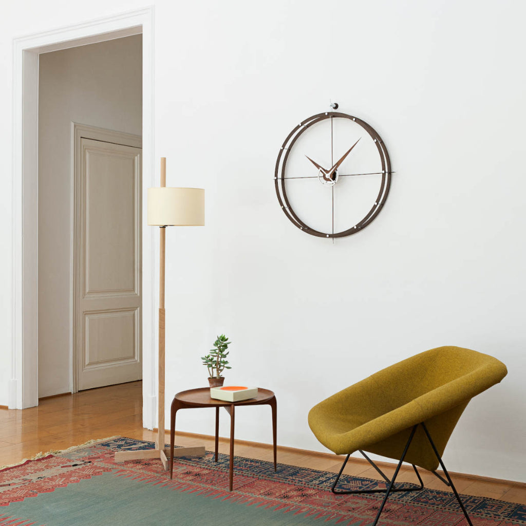 Modern living room with a yellow chair, round wooden table, and wall clock.