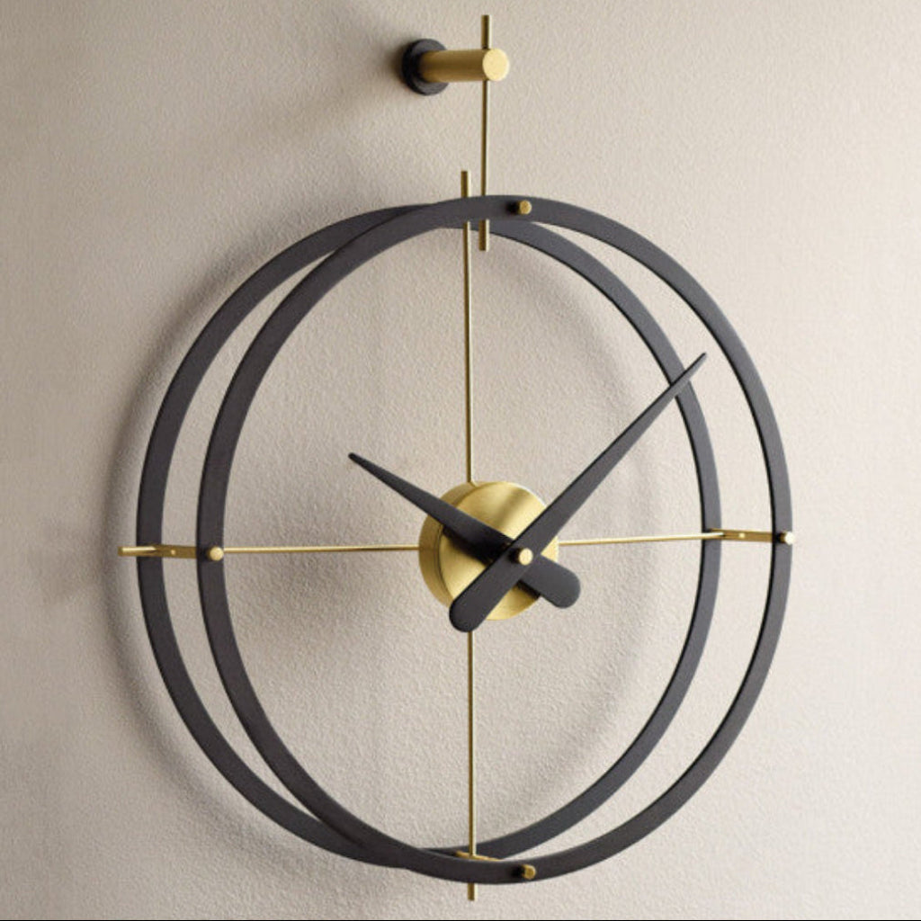 Modern wall clock with black and gold design on a beige wall