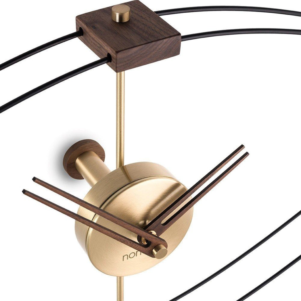 Modern wall clock with gold and wood design on a white background