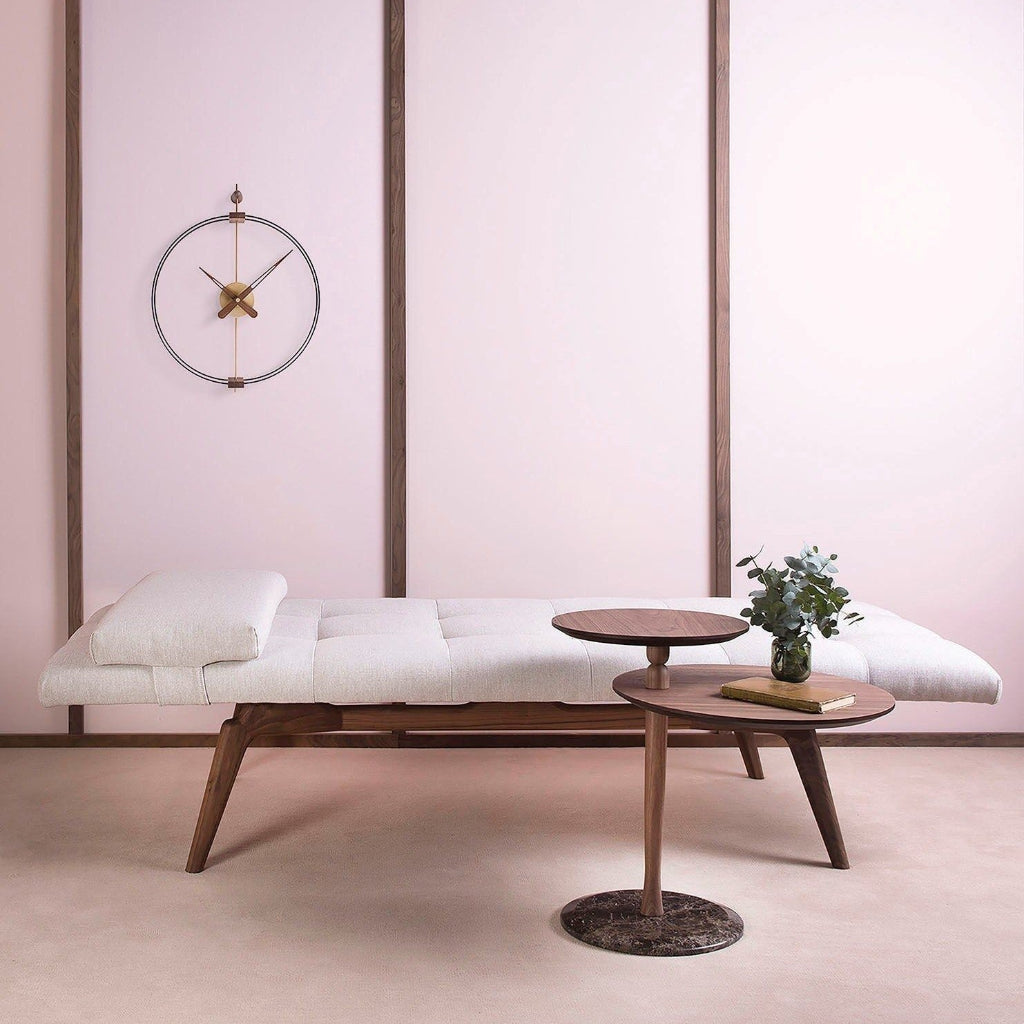 Modern interior with a bench, small round table, and decorative items against a pink wall.