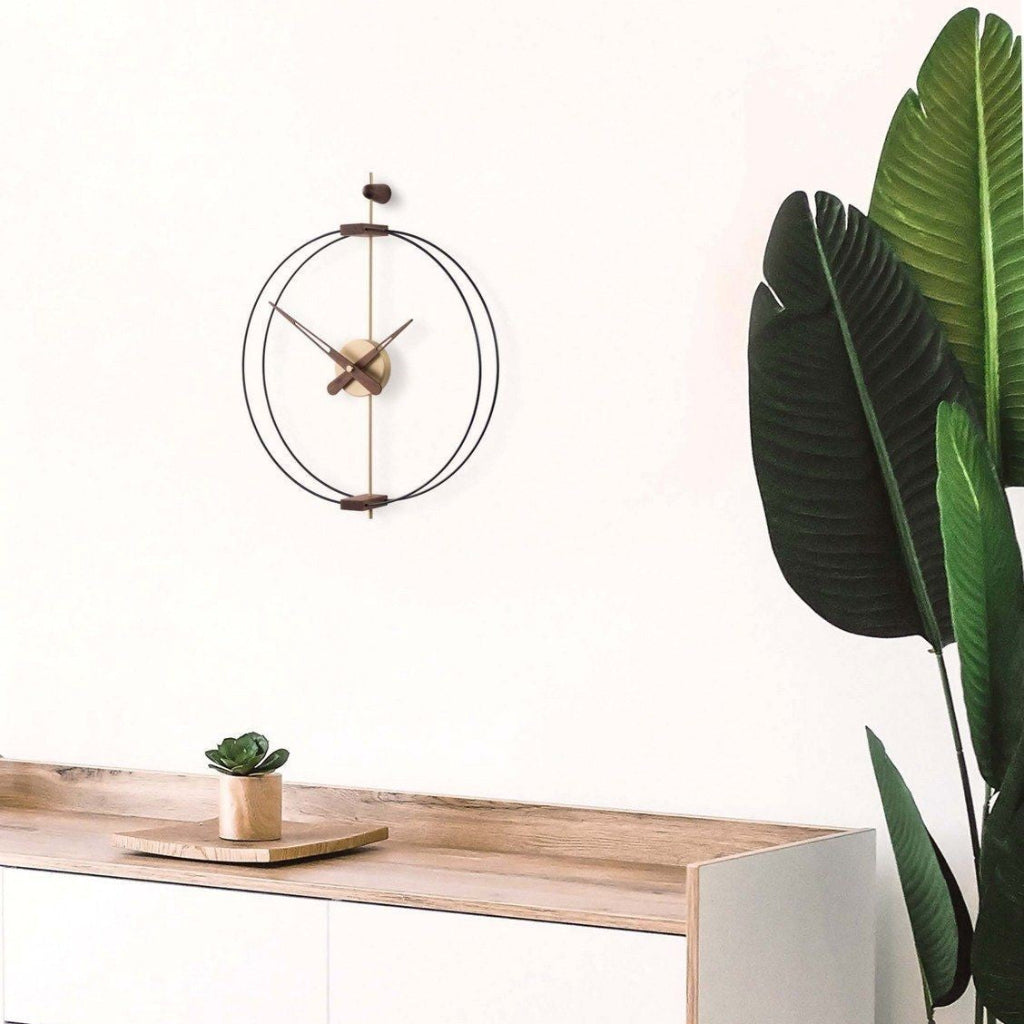 Modern clock on a wooden surface with a plant in the corner