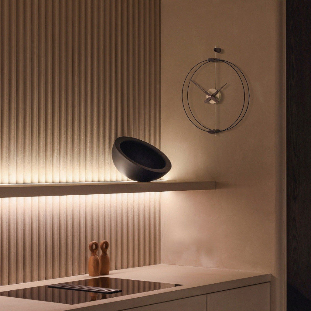 Modern kitchen interior with a wall-mounted clock and decorative elements.