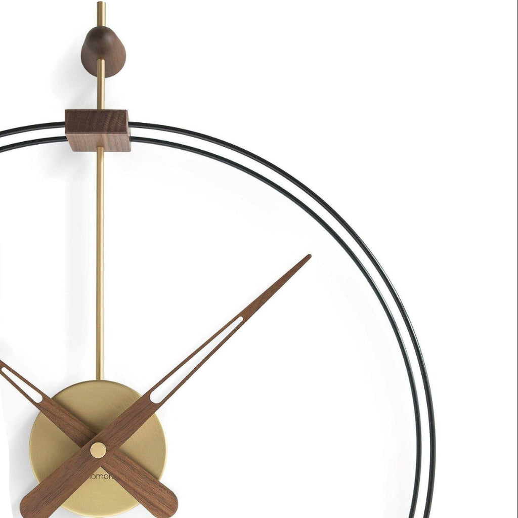 Modern wall clock with wooden and brass accents on a white background