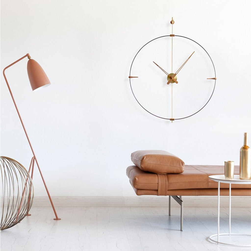 Modern interior with a wall clock, lamp, and sofa against a white wall.