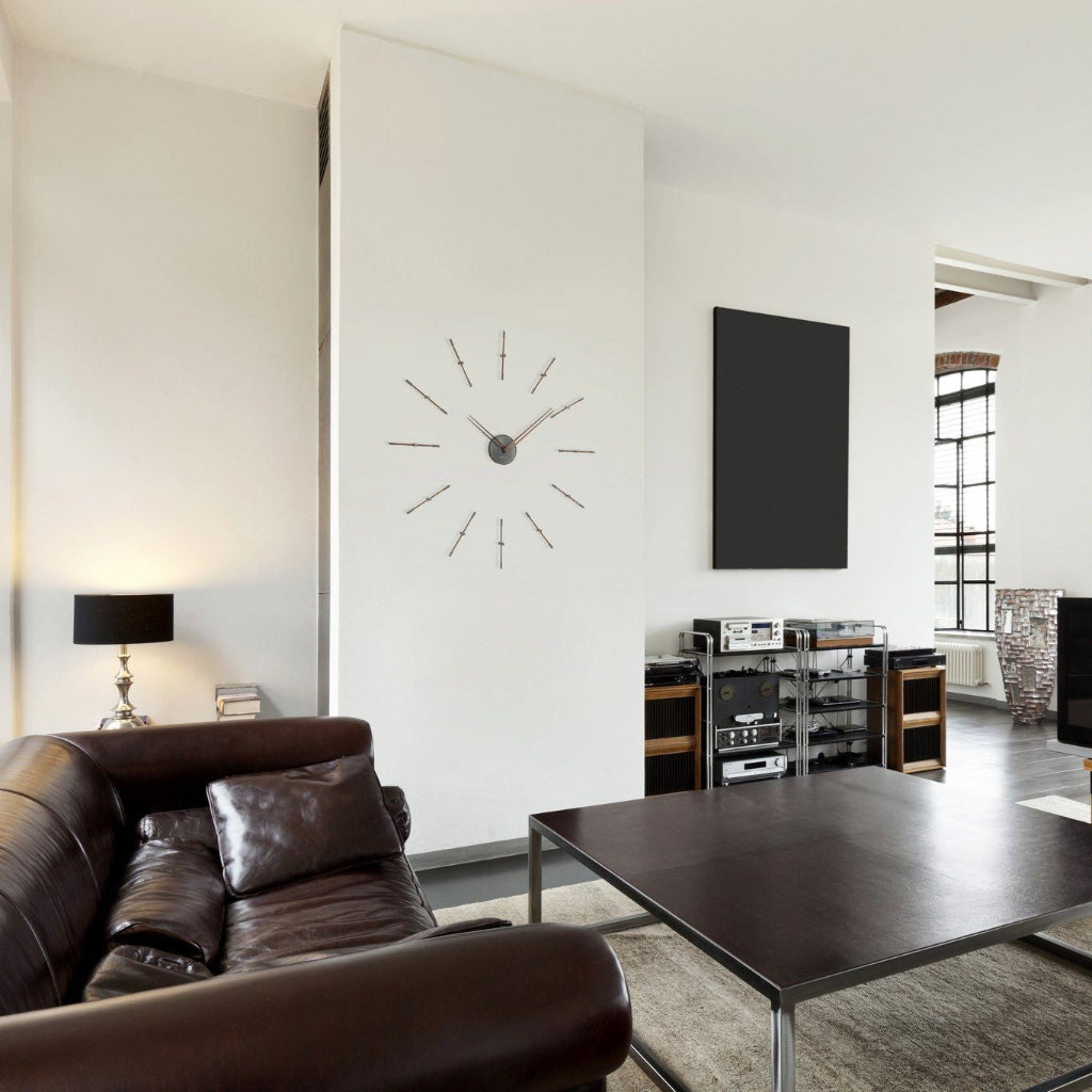 Modern living room with a brown leather sofa, dark wood coffee table, and decorative wall clock.