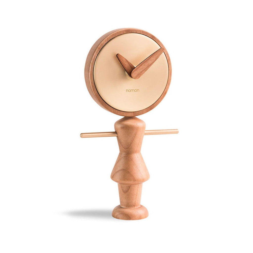 A Nomon Nena Oak and Brass NENARG wooden clock featuring a charming wooden figure on it. available at Spacio retail stores in Mumbaii & Kolkata and online.