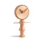 A Nomon Nena Oak and Brass NENARG wooden clock featuring a charming wooden figure on it. available at Spacio retail stores in Mumbaii & Kolkata and online.