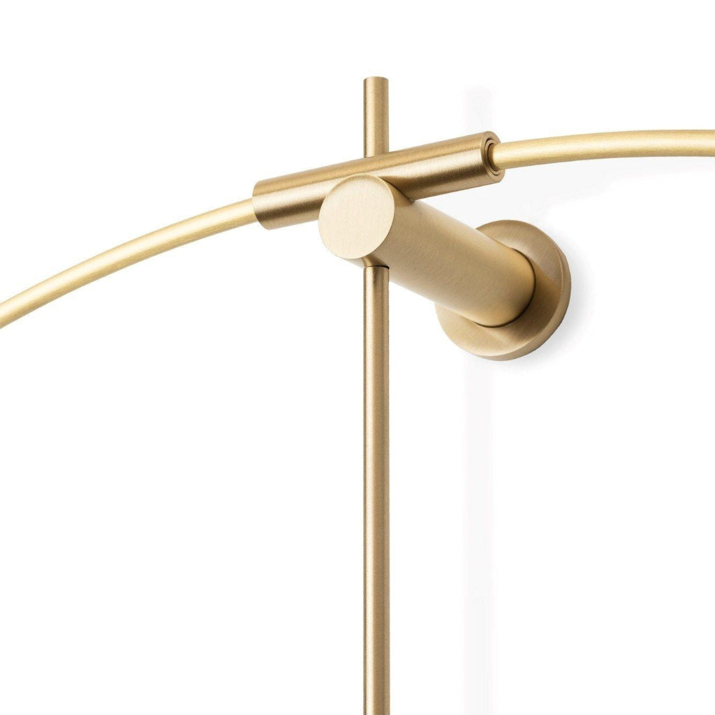 Gold wall-mounted lamp with a curved arm on a white background