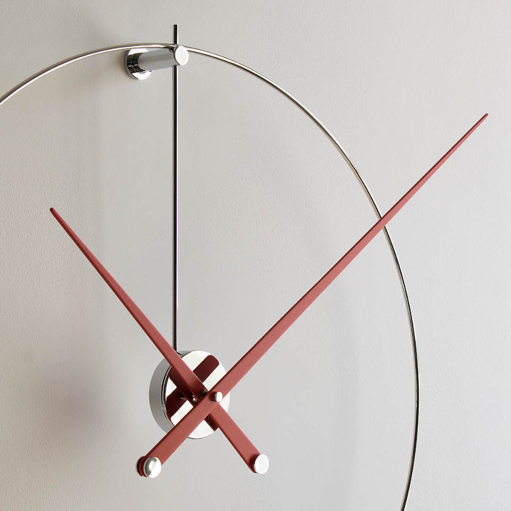 Modern wall clock with red and black hands on a light gray background