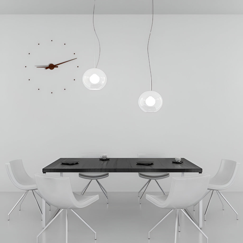 Modern dining area with a black table and white chairs under pendant lights.