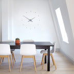 Modern dining area with a black table and white chairs in a bright room.