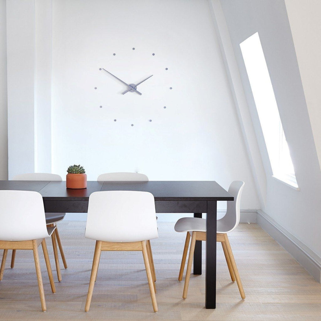 Modern dining area with a black table and white chairs in a bright room.