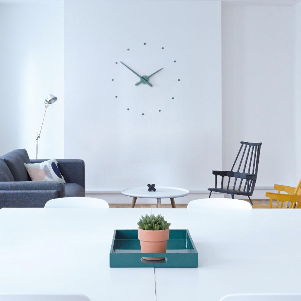 Modern living room with a clock on the wall, a plant in a tray, and furniture.