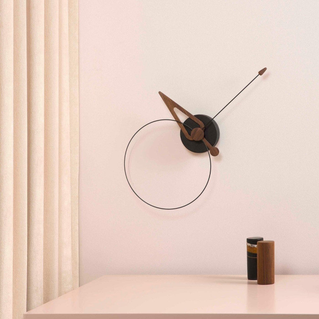 Modern wall clock with wooden accents on a light pink wall.