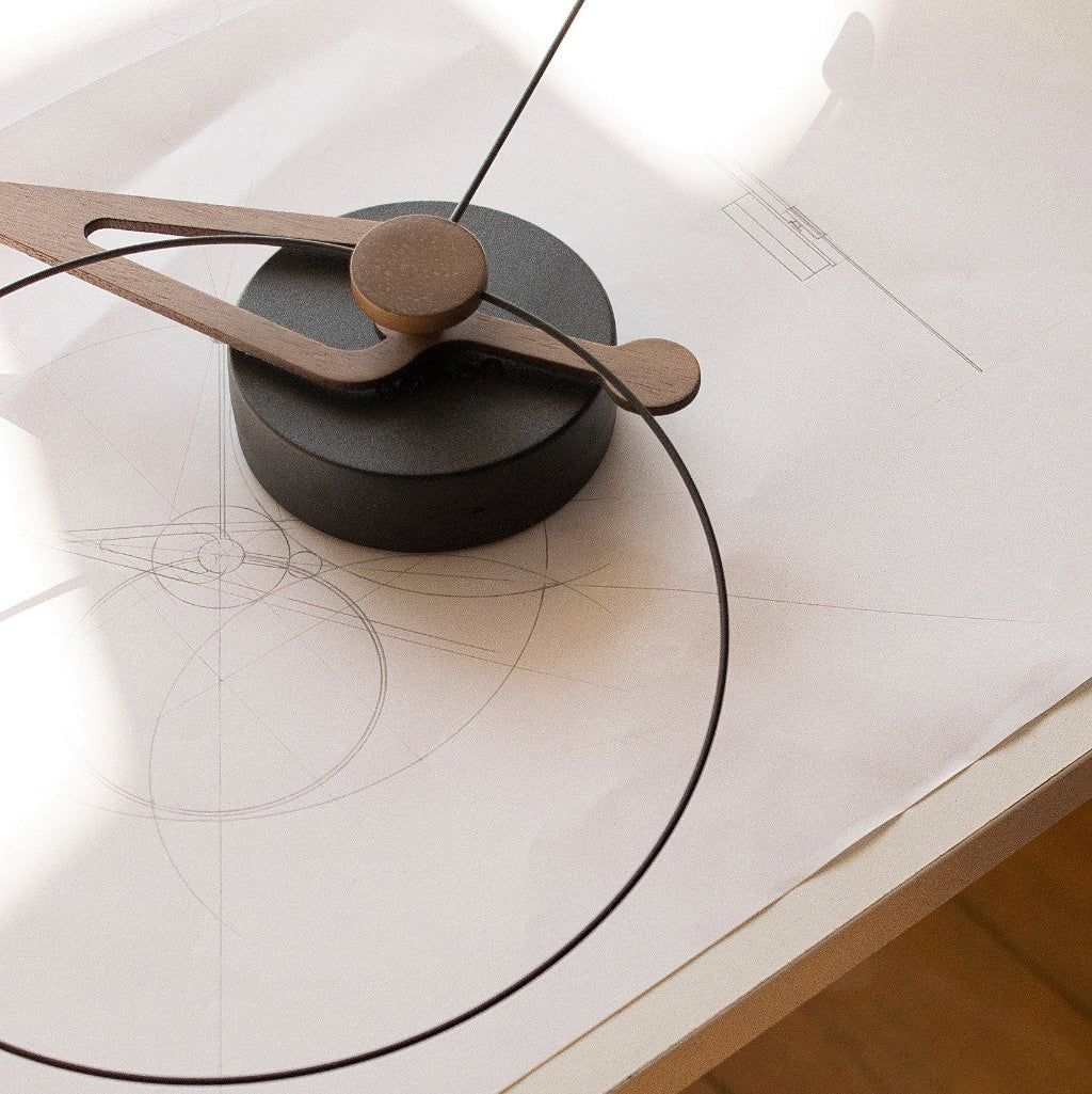 Modern clock with wooden hands on a white surface