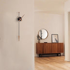 Modern interior with a wooden sideboard, round mirror, and wall clock.