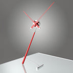 Modern wall clock with red arms on a gray background