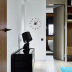 Modern interior with a black lamp and clock on a white wall.