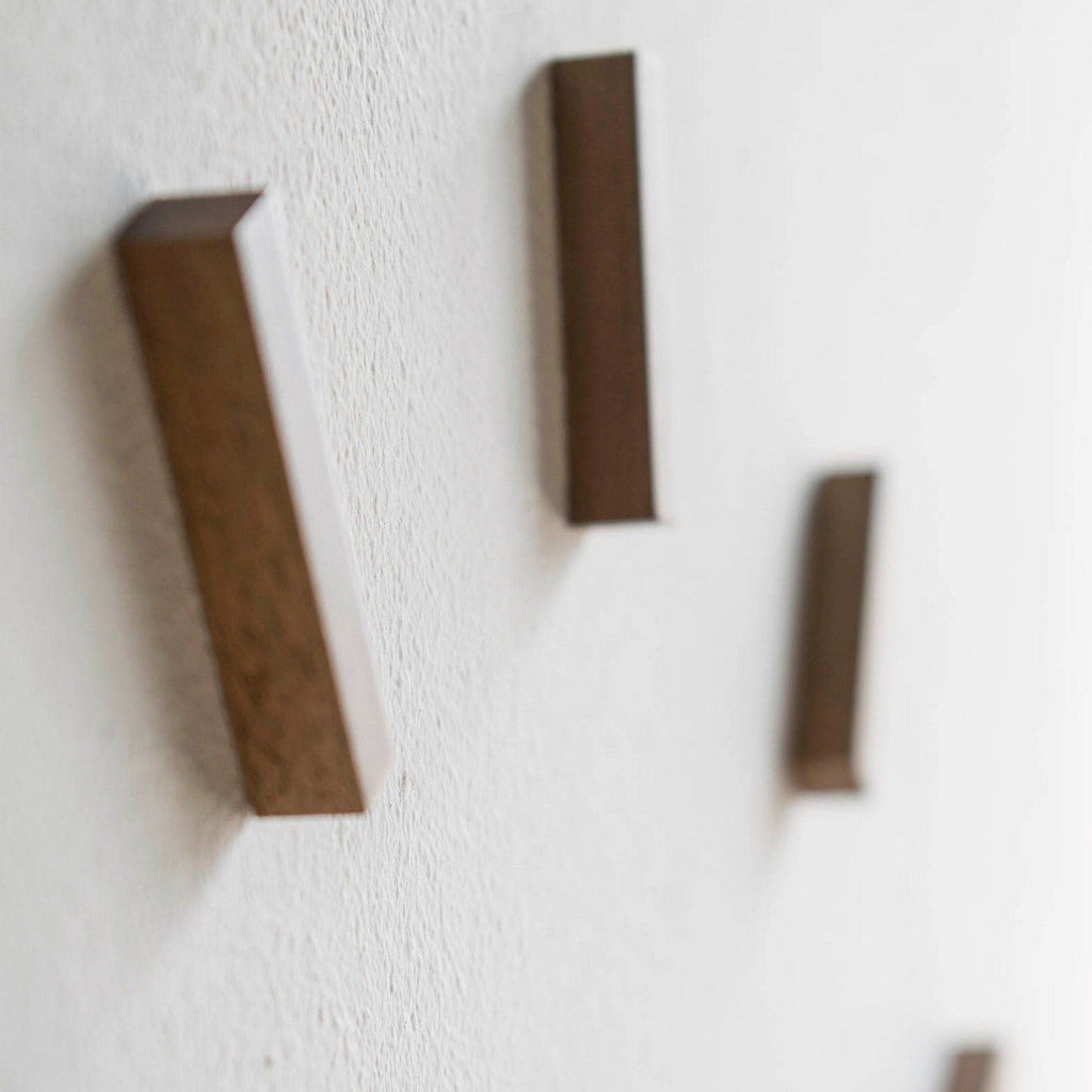 Three rectangular wooden blocks on a textured white surface