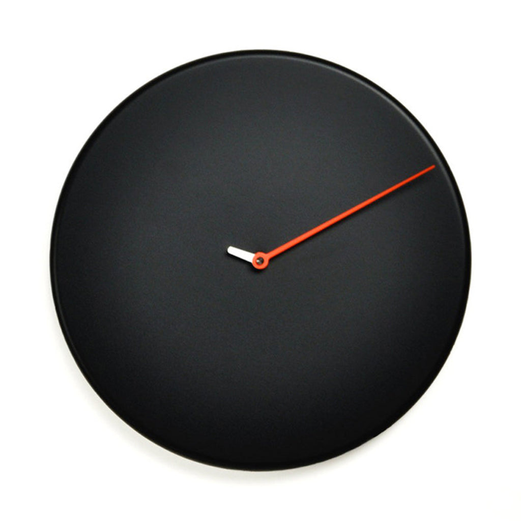 Black wall clock with a red second hand on a white background from Progetti available at Spacio retail stores in Mumbaii & Kolkata and online.