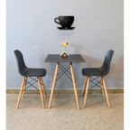 Small dining table with two black chairs against a light gray wall.